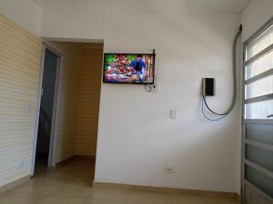 a flat screen tv on a wall in a room at apartment 1 bedroom in Mongaguá