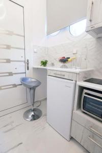 a kitchen with a stool in a white kitchen at Nafplio Private Studio 1 in Nafplio