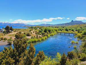 a bridge over a river with mountains in the background at Domo Kumelén Mahuida in Junín de los Andes