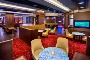 a hotel lobby with tables and chairs and a flat screen tv at Philadelphia Airport Marriott in Philadelphia