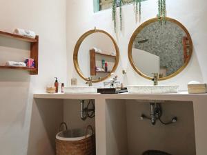 a bathroom with two sinks and two mirrors at Aashaya Jasri Resort in Jasri