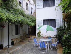 a table and chairs with an umbrella on a patio at Hostel das Flores - Centro 131 in Ouro Preto