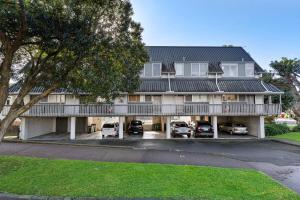 a large house with cars parked in front of it at Luxury townhouse with aircon, huge balcony & hot tub in Auckland