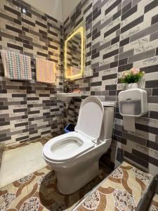 a bathroom with a toilet and a sink at Citrus Duplex Getaway in Dawhwenya