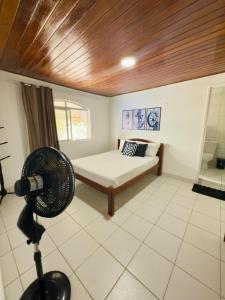 a room with a bed and a fan in a room at Guest House Rosa do Mar in Olinda