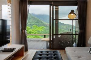 een woonkamer met uitzicht op een berg bij The Pino Khao Kho in Phetchabun