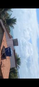 einen Himmel mit Palmen und einem Gebäude in der Unterkunft Casa DE PRAIA EM BÚZIOS RN in Nísia Floresta