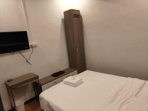 a small bedroom with a bed and a tv at The Spring in Pattaya