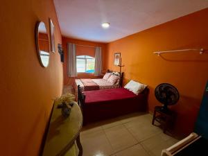 a small room with a couch and a bed in it at Guest House Rosa do Mar in Olinda