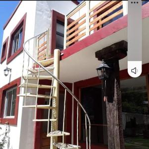 un edificio con una escalera de caracol delante de él en El jardín, en General Juan Madariaga