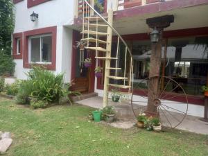 una casa con una escalera de caracol junto a una rueda en El jardín, en General Juan Madariaga