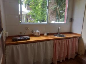 Una encimera de cocina con un fregadero y una ventana. en El jardín, en General Juan Madariaga
