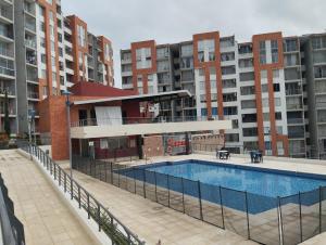 ein Schwimmbad vor einigen Wohnhäusern in der Unterkunft Apartaestudio Vacacional en Girardot, piscinas, Jacuzis, parqueadero para moto in Girardot