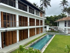 an external view of a building with a swimming pool at Marshmallow Bay Boutique Hotel & Surf Point Adults Only in Ahangama
