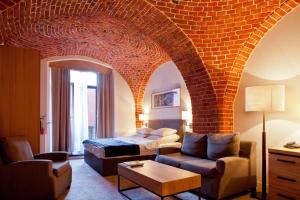 a living room with a bed and a brick wall at The Granary - La Suite Hotel in Wrocław