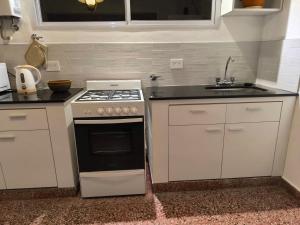 a kitchen with a stove and a sink at La casa in Gualeguaychú