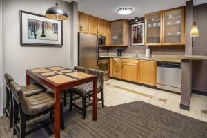 a kitchen with a table and chairs in a room at Residence Inn Burlington Colchester in Burlington