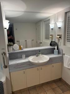 ein Badezimmer mit Waschbecken und Spiegel in der Unterkunft Five o clock somewhere in Golden Beach + 16 Fotos