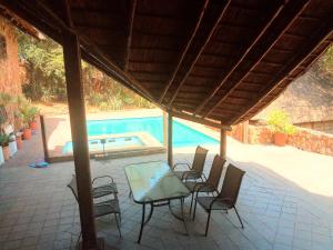 a patio with chairs and a table and a swimming pool at VILLA LA CORRIE Guest Lodge in Steelpoort