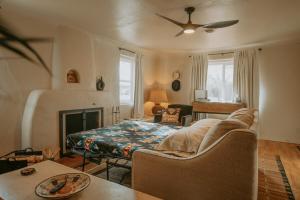a living room with a couch and a bed at Grandma's Old Town Adobe House! Hot Tub & Pet Friendly & No Pet Fee! in Albuquerque