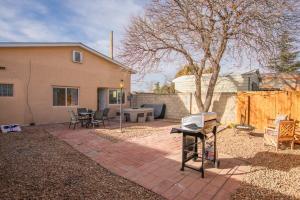 a backyard with a barbecue grill and a house at Grandma's Old Town Adobe House! Hot Tub & Pet Friendly & No Pet Fee! in Albuquerque