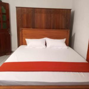 Un dormitorio con una cama con cabecero de madera. en Piya House, en Weligama