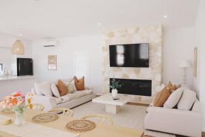 a living room with white furniture and a fireplace at The Arv in Robe