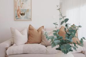 a living room with a couch with pillows and a plant at The Arv in Robe