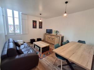 a living room with a couch and a wooden table at Appartement lumineux 2 ch, proche plage & commerces - FR-1-706-31 in Châtelaillon-Plage