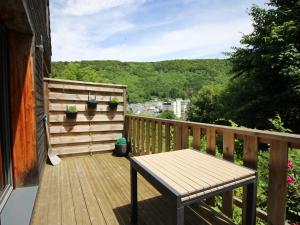 a wooden deck with a table and plants on it at Chalet au Mont-Dore, 8 pers, 3 ch, animaux admis, parking, terrasse, proche centre - FR-1-608-281 in Mont-Dore
