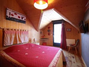a bedroom with a large red bed in a attic at Chalet Mont-Dore 110m², 10 pers, parking, animaux admis - FR-1-608-280 in Mont-Dore