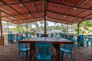 a wooden table and chairs under a pavilion at CASA DE CAMPO CASTILLETE dentro del PARQUE TAYRONA in El Zaino