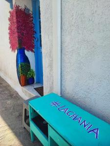 a blue bench sitting next to a vase of flowers at Studio Lachania in Lachania +9 photos