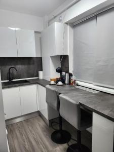 a kitchen with white cabinets and a counter top at Garsoniera de lux cu balcon in Craiova