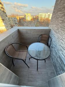 two chairs and a table on a balcony at Garsoniera de lux cu balcon in Craiova