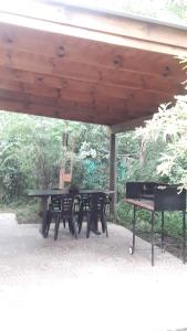 a picnic table and two benches under a pavilion at La arbolada in Villa Ciudad Parque +19 photos
