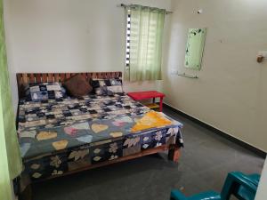 a bedroom with a bed with a quilt on it at SHIVADIVYA Homestay Hampi in Hampi