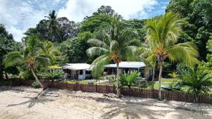 a house on the beach with palm trees at Vavau Beachfront Villas in Utungake