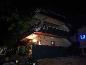 a house at night with people standing in front of it at SHIVADIVYA Homestay Hampi in Hampi
