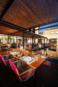 a wooden table with chairs and plates of food on it at The Romanos, a Luxury Collection Resort, Costa Navarino in Romanu