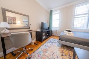 a bedroom with a bed and a desk and a computer at Bright Studio in Central NYC in New York