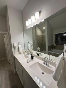 a bathroom with two sinks and a large mirror at Beautiful spacious house with great location! in Conroe +20 photos