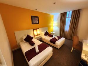 Una cama o camas en una habitación de The Grand Puteri Hotel