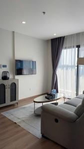 Nam Tu LiemにあるỞ Nhà Apartment Vinhomes Smart Cityのソファとテーブルのあるリビングルーム