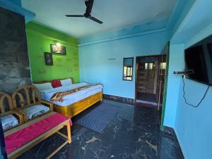 a bedroom with two beds and a tv in it at Ramda cottages in Almora