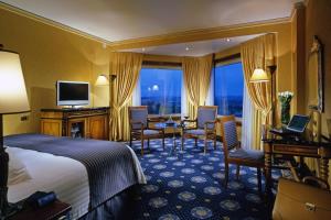 a hotel room with a bed and a table and chairs at Rome Marriott Park Hotel in Rome
