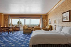 a hotel room with a bed and a table and chairs at Rome Marriott Park Hotel in Rome
