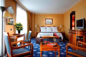 a hotel room with a bed and a table and chairs at Rome Marriott Park Hotel in Rome