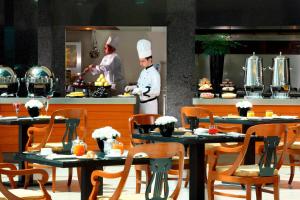 two chefs in a restaurant kitchen with tables at Rome Marriott Park Hotel in Rome