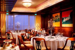 a dining room with tables and chairs with white table cloth at Rome Marriott Park Hotel in Rome